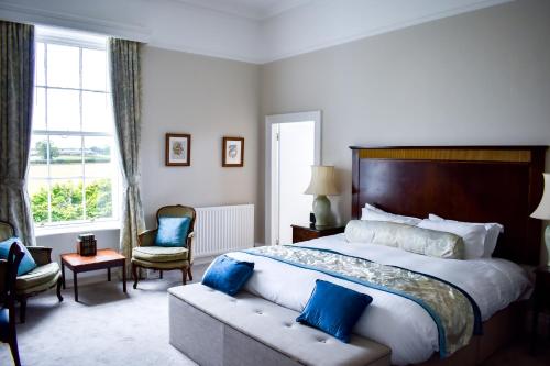 a bedroom with a large bed with blue pillows at Dovecliff Hall Hotel in Burton upon Trent