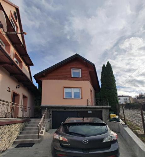 a car parked in front of a house at Domek u Lucy in Rabka