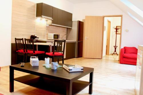 - un salon avec une table et un canapé rouge dans l'établissement City Center Apartman Miskolc, à Miskolc