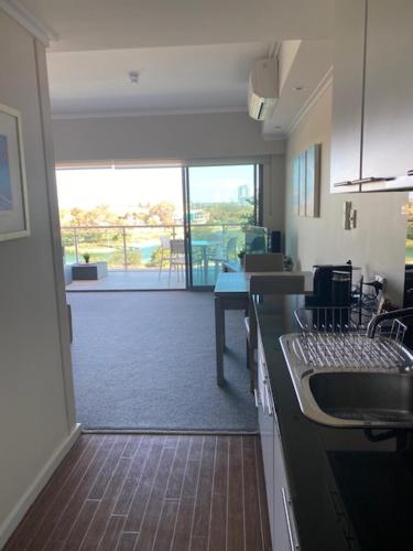 a kitchen with a view of a living room at Dolphin View 404 in Mandurah