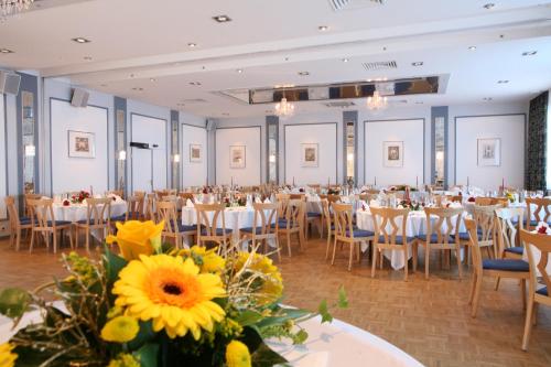um salão de banquetes com mesas, cadeiras e flores em Zum Starenkasten GmbH em Braunschweig