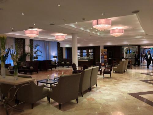 a hotel lobby with tables and chairs and lights at Cairo Pyramids Hotel in Cairo