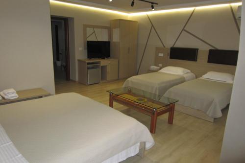 a hotel room with two beds and a television at Freddy's Hotel in Tirana