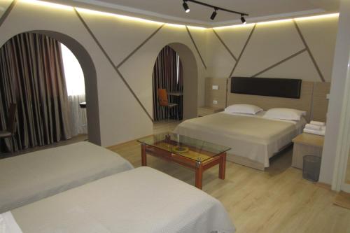 a hotel room with two beds and a table at Freddy's Hotel in Tirana