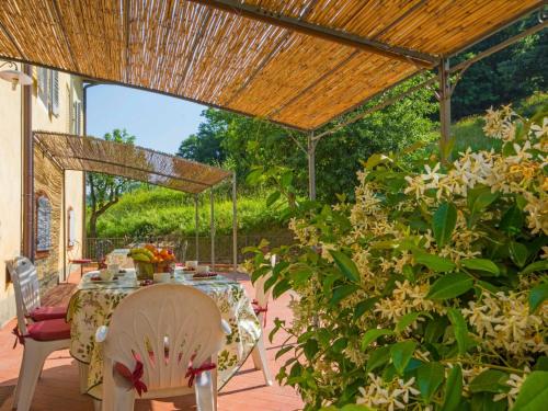 un patio con mesa y sillas bajo una pérgola en Apartment Alba by Interhome, en Serravalle Pistoiese