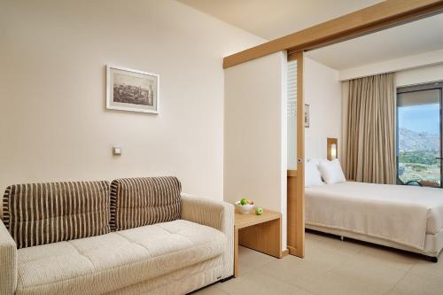 a living room with a couch and a bed and a window at Princess Sun Hotel in Kiotari