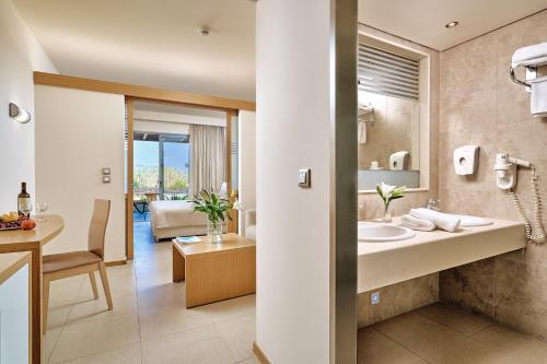 een badkamer met een wastafel en een woonkamer bij Princess Sun Hotel in Kiotari