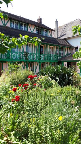 une maison avec un jardin fleuri devant elle dans l'établissement Le Jardin des Merveilles, à Saint-Pierre-dʼAutils