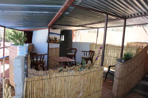 a porch with chairs and a table and a fence at YoIeli Guest House in Windhoek