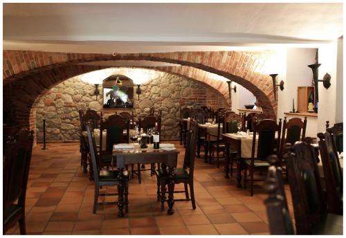 a dining room with tables and chairs and a stone wall at Seeschloss Schorssow in Schorssow