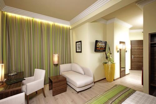 Pokój hotelowy z krzesłem, biurkiem i telewizorem w obiekcie Hotel Vienna beim Prater w Wiedniu
