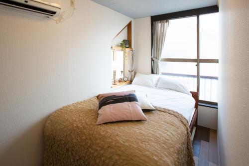 東京にあるBike & Bed East Tokyo,5rooms,9ppl,9bicyclesの大きな窓のあるベッドのある寝室