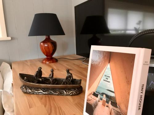 a table with a lamp and a picture of a boat on it at Sheelin Shepherds Hut in Cavan