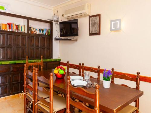 uma sala de jantar com uma mesa de madeira e cadeiras em Apartment Adelfa apt- 1 by Interhome em Sant Martí d’Empúries