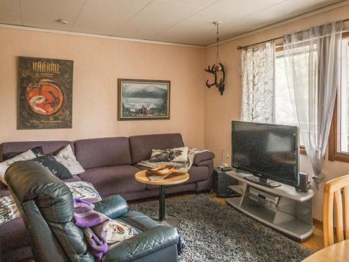 een woonkamer met een bank en een tv bij Holiday Home Kesänkilehto by Interhome in Äkäslompolo