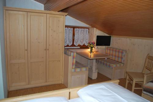 a bedroom with a desk and a bed and a table at Albergo Pineta in Castello di Fiemme