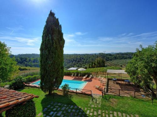 モンテルーポ・フィオレンティーノにあるHoliday Home Il Frantoio by Interhomeのプールと木のある別荘のイメージ