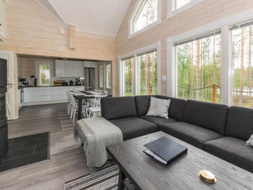 a living room with a couch and a table and a kitchen at Holiday Home Miilu by Interhome in Jyrkkä