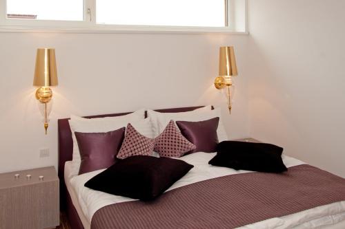 a bedroom with a bed with purple and white pillows at Deluxe Apartment Sonnleitner - ADULTS ONLY in Furth