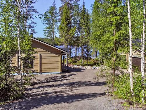 a cabin in the woods next to a road at Holiday Home Villa mari by Interhome in Pertunmaa