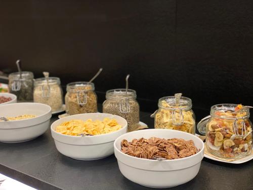 a table with bowls of food and jars of food at Park Hotel Villa Etschland in Plaus