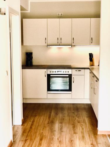 a kitchen with white cabinets and a stove at Spreewaldapartments-Kossatz in Lübben