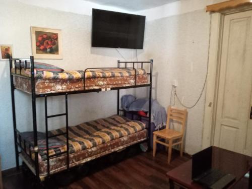 two bunk beds in a room with a flat screen tv at My Hostel and Cooking House! in Tbilisi City