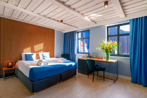 a bedroom with a bed and a desk with a desk at Kurort Kameralny in Mikołajki