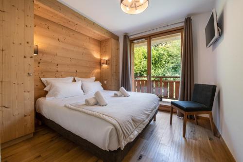1 dormitorio con 1 cama, 1 silla y 1 ventana en K2 by Alpine Residences, en Les Gets
