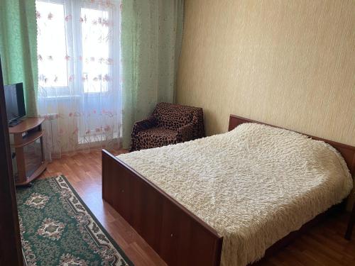 クルスクにあるApartments on prospekt Vyacheslav Klykova 80のベッドルーム1室(ベッド1台、椅子、窓付)