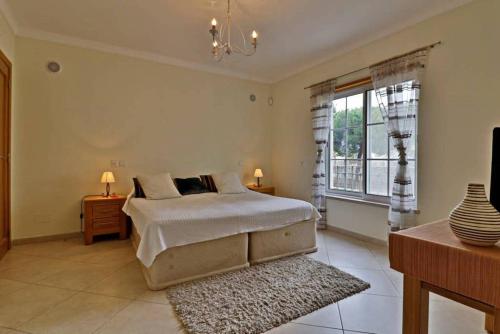- une chambre avec un lit et une grande fenêtre dans l'établissement Villa Varandas Do Lago - 5 Bedroom villa - Stunning pool area - Table tennis, à Vale do Lobo