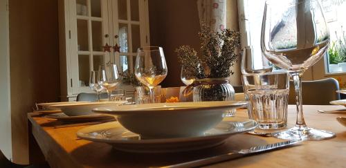 una mesa de madera con platos y copas de vino. en super gemütlich - DasPaterhaus en Monschau