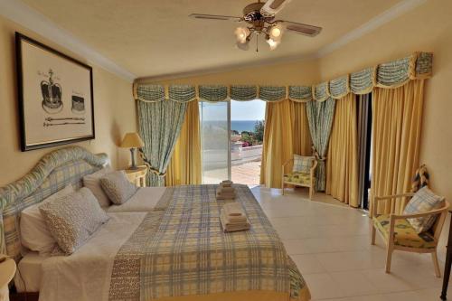 a bedroom with a large bed and a large window at Villa Vale Do Lobo 409 - beautiful 5BR with heated pool short walk to Praca in Vale do Lobo