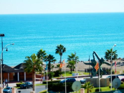 a view of a beach with palm trees and the ocean at playamar in Torremolinos