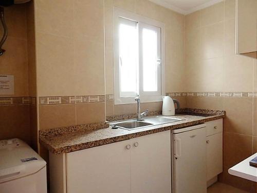 eine kleine Küche mit einem Waschbecken und einem Fenster in der Unterkunft Bleu Mare Apartment in Torremolinos