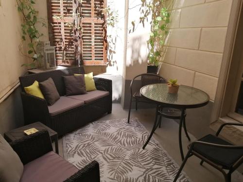 a patio with a couch and a table and chairs at Limoux Vacances in Limoux