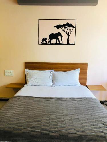 a bedroom with a bed with a picture of elephants at Udaya Resort in Palakkad