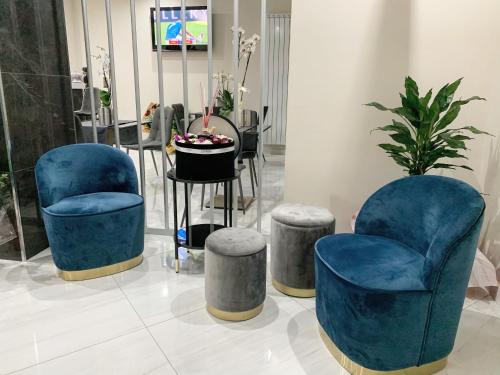 a room with two blue chairs and a table at Hotel Trionfal in Qualiano