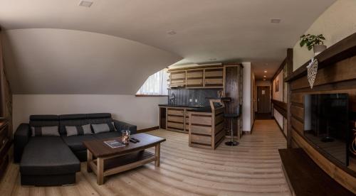 a living room with a couch and a table at Nestville Apartments in Hniezdne