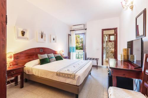 een slaapkamer met een bed, een bureau en een tafel bij Hotel S'Ortale in Orosei