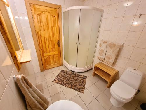 a bathroom with a toilet and a walk in shower at Kunči in Priekuļi