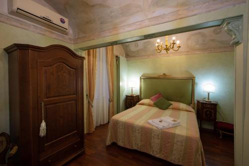 una camera con letto e lampadario a braccio di Antica Dimora Isernia a Isernia