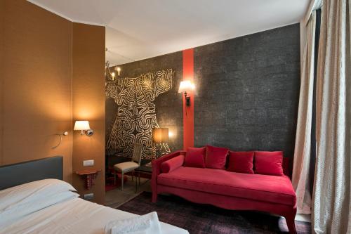 um quarto com um sofá vermelho num quarto em Turin Tales Luxury Apartments em Turim