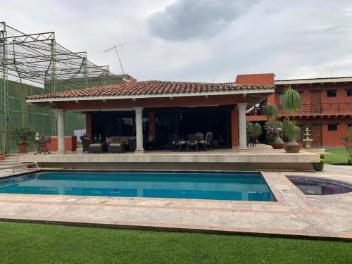 a house with a swimming pool in the yard at Un oasis de tranquilidad y diversión familiar in Yautepec