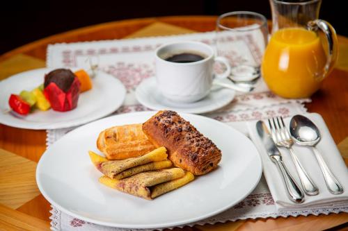 a table with two plates of food and a cup of coffee at Hotel Natale in Cortina dʼAmpezzo