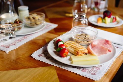 a table with plates of food on a wooden table at Hotel Natale in Cortina dʼAmpezzo