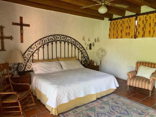 a bedroom with a large bed and a chair at Un oasis de tranquilidad y diversión familiar in Yautepec