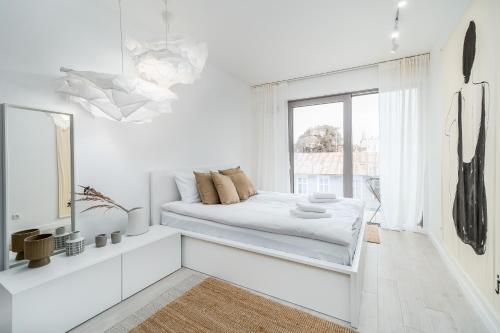 a white room with a bed and a window at Apartment Balticus 19A by Renters in Międzyzdroje