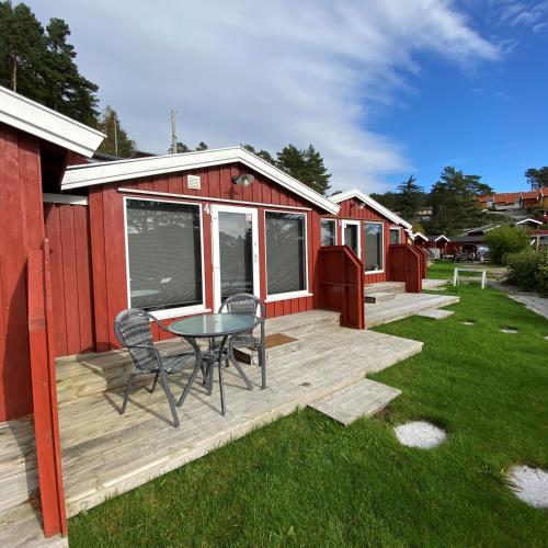 a deck with a table and chairs on a house at Tregde Ferie in Mandal