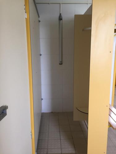 a bathroom with a shower and a tiled floor at Auberge de jeunesse-La Hulotte in Montreuil-sur-Mer